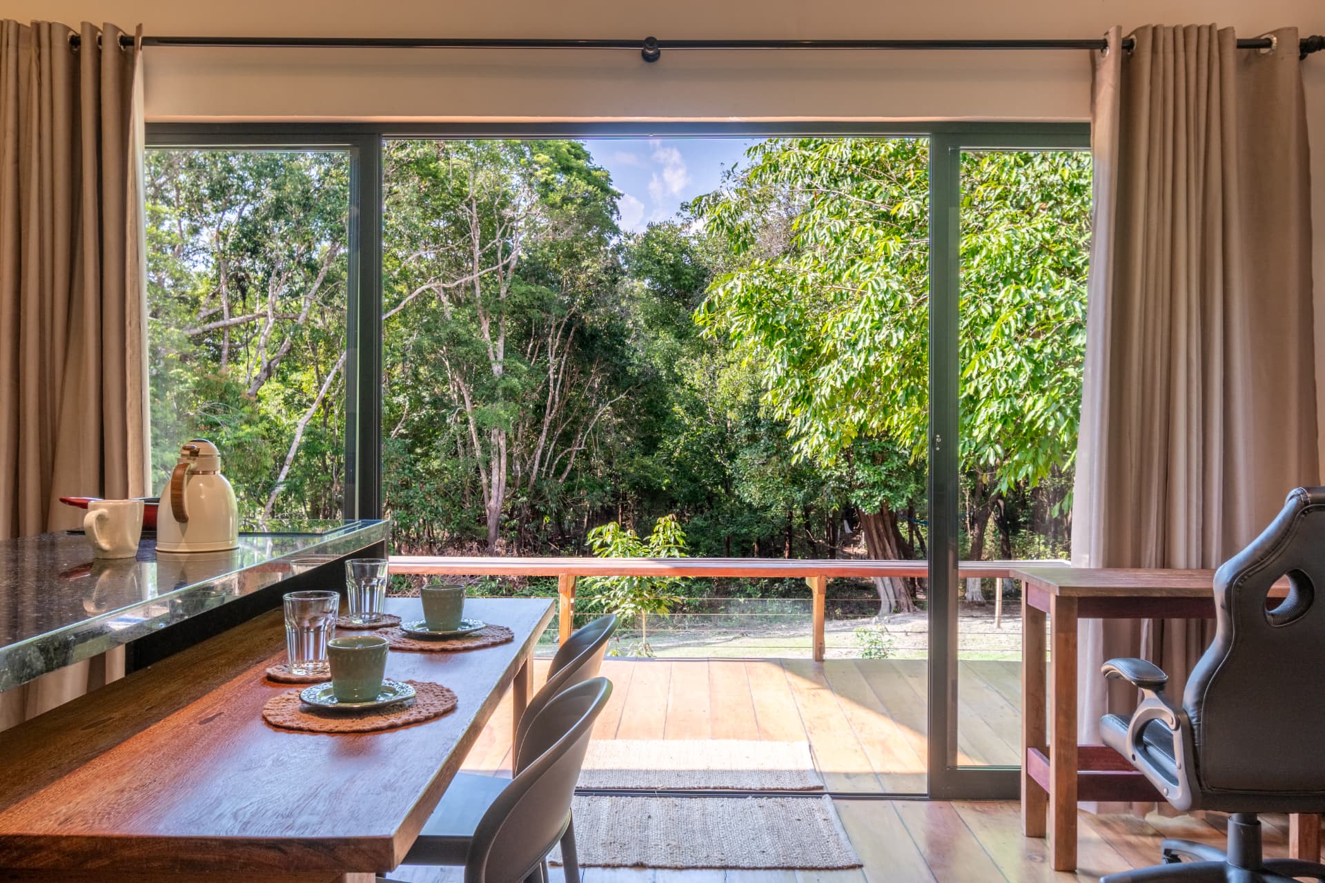 Dining table and sliding doors opening onto the rainforest