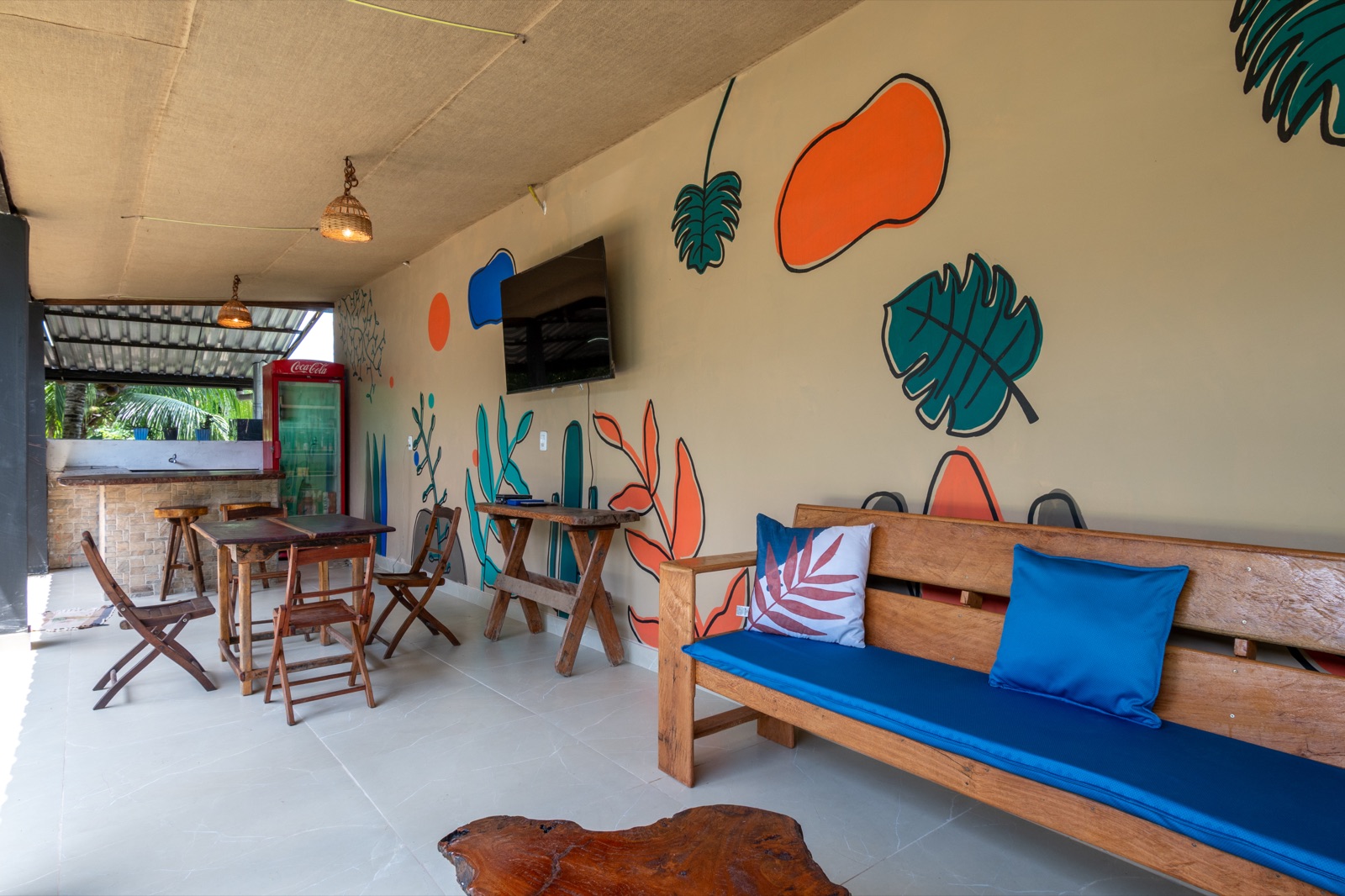 Tribo Hospedagem shared lounge with hand-painted mural